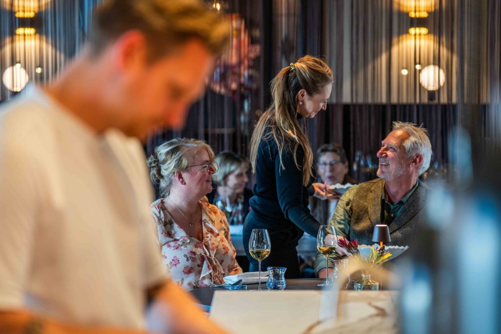 Een chef van Ode vertelt gasten aan tafel over het gerecht