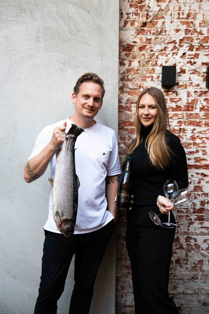 Liudger en Ryanne tonen een verse vis voor een bakstenen muur