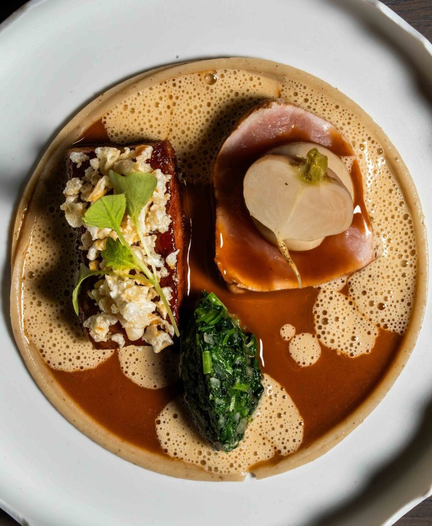 Een gerecht met bouillon en garnituur, van boven gefotografeerd