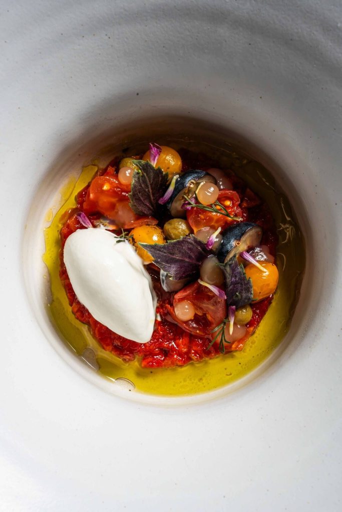 Een kleurrijk gerecht met een romige quenelle in een witte kom