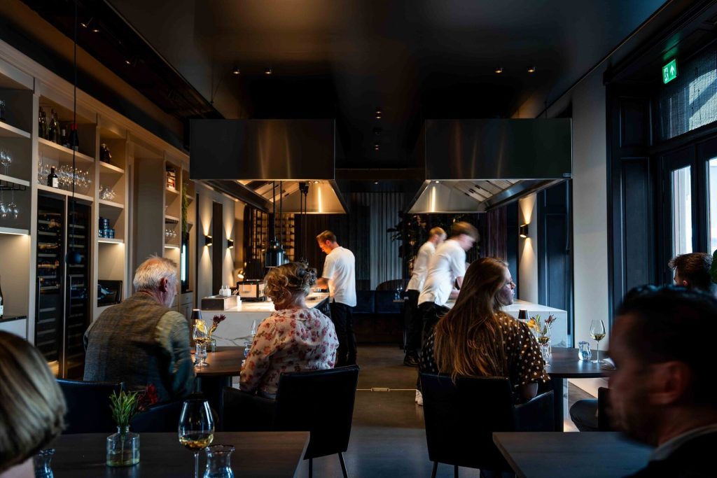 Het restaurant van Ode met de open keuken en gasten aan tafel