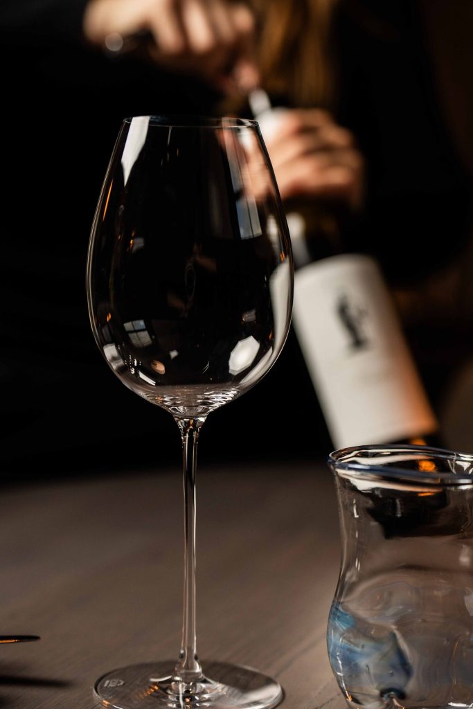 Een wijnfles en glas staan klaar op tafel bij Restaurant Ode